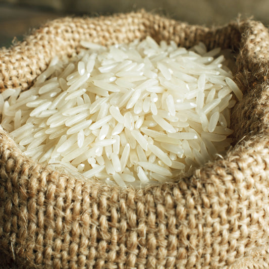 Uncooked Basmati Rice Long Grain fills a rustic hessian sack, showing the slender white grains and their natural uncooked texture.
