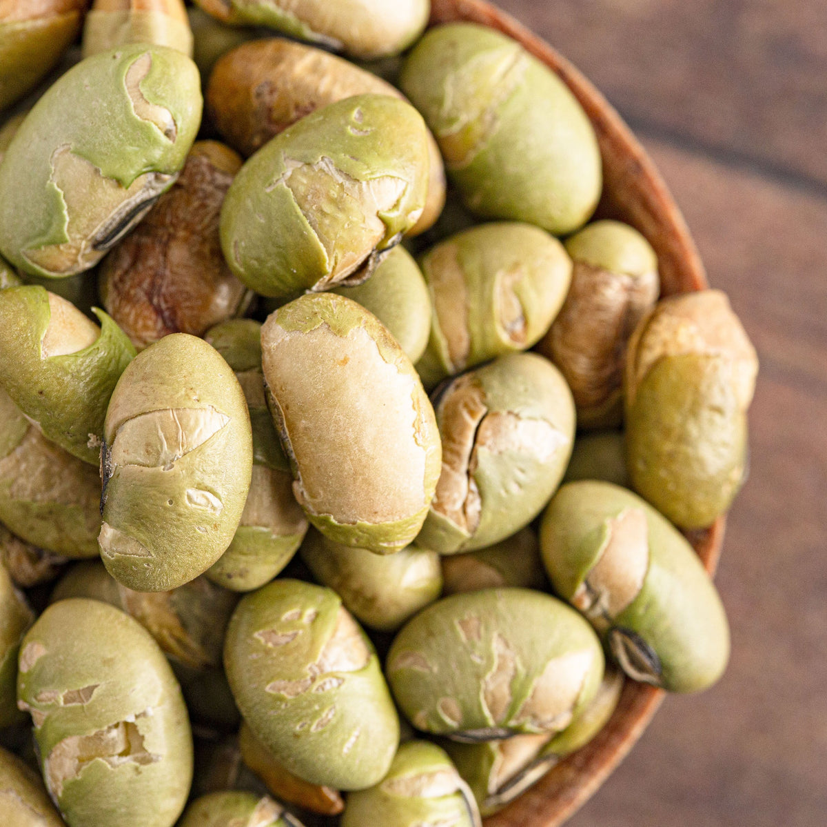 A close-up of Dry Roasted Salted Edamame piled in a wooden spoon, showing the smooth pale green beans and roasted texture, from The Herb Shed Wollongong Australia.