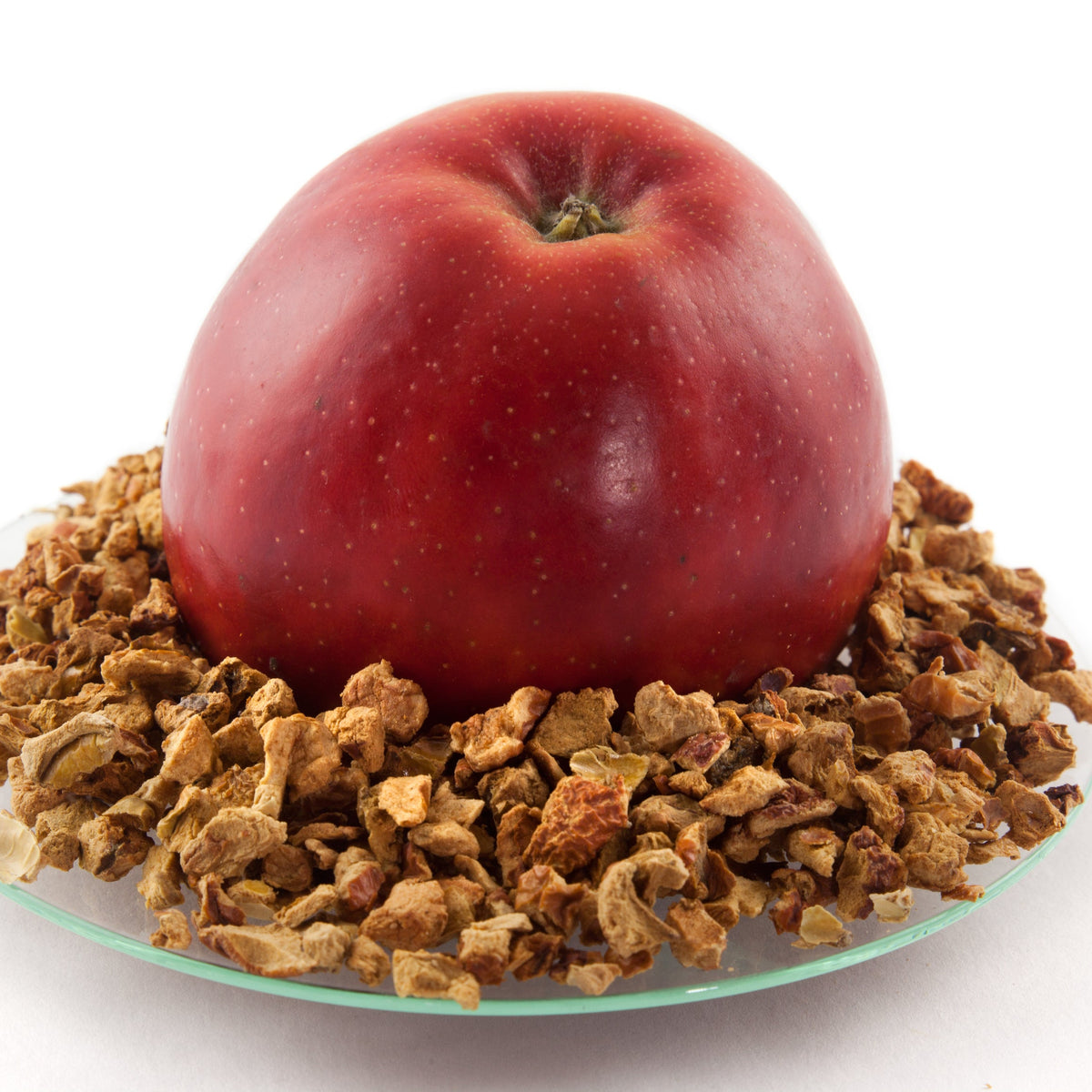 A fresh red apple sits surrounded by Organic Apple Pieces Dried, showing the fresh fruit alongside the dried apple pieces.