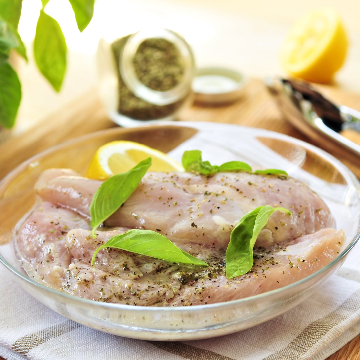 Chicken breasts seasoned with dried mixed herbs are served on a white plate and garnished with fresh green herbs.