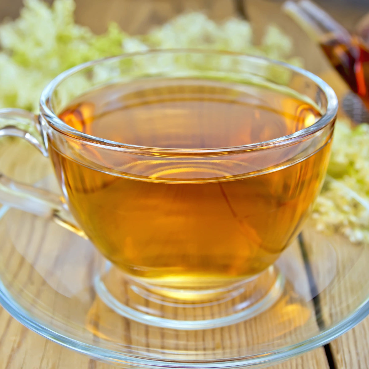 A clear glass cup of golden herbal tea, showing Organic Meadowsweet Herb from The Herb Shed in Wollongong, Australia, prepared as a warm herbal infusion.