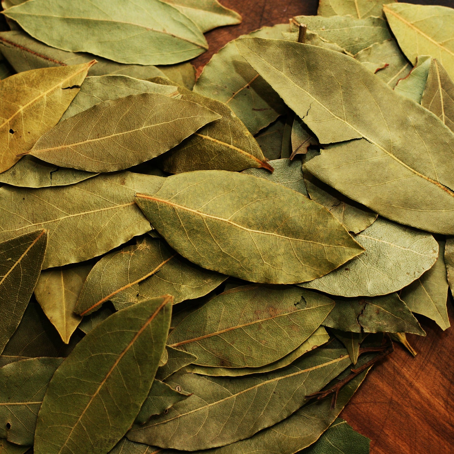 Pile of bay leaves on a table – fragrant, earthy herb from The Herb Shed Wollongong