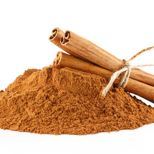 Cinnamon powder in a pile with two cinnamon quills on top on a white background – warm aromatic spice from The Herb Shed Wollongong