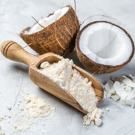 Organic coconut flour with coconut halves and wooden scoop from The Herb Shed Wollongong