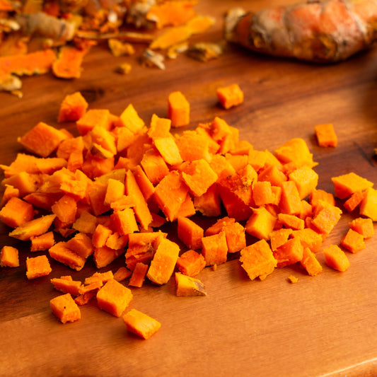 Organic turmeric root pieces on wooden surface from The Herb Shed Wollongong