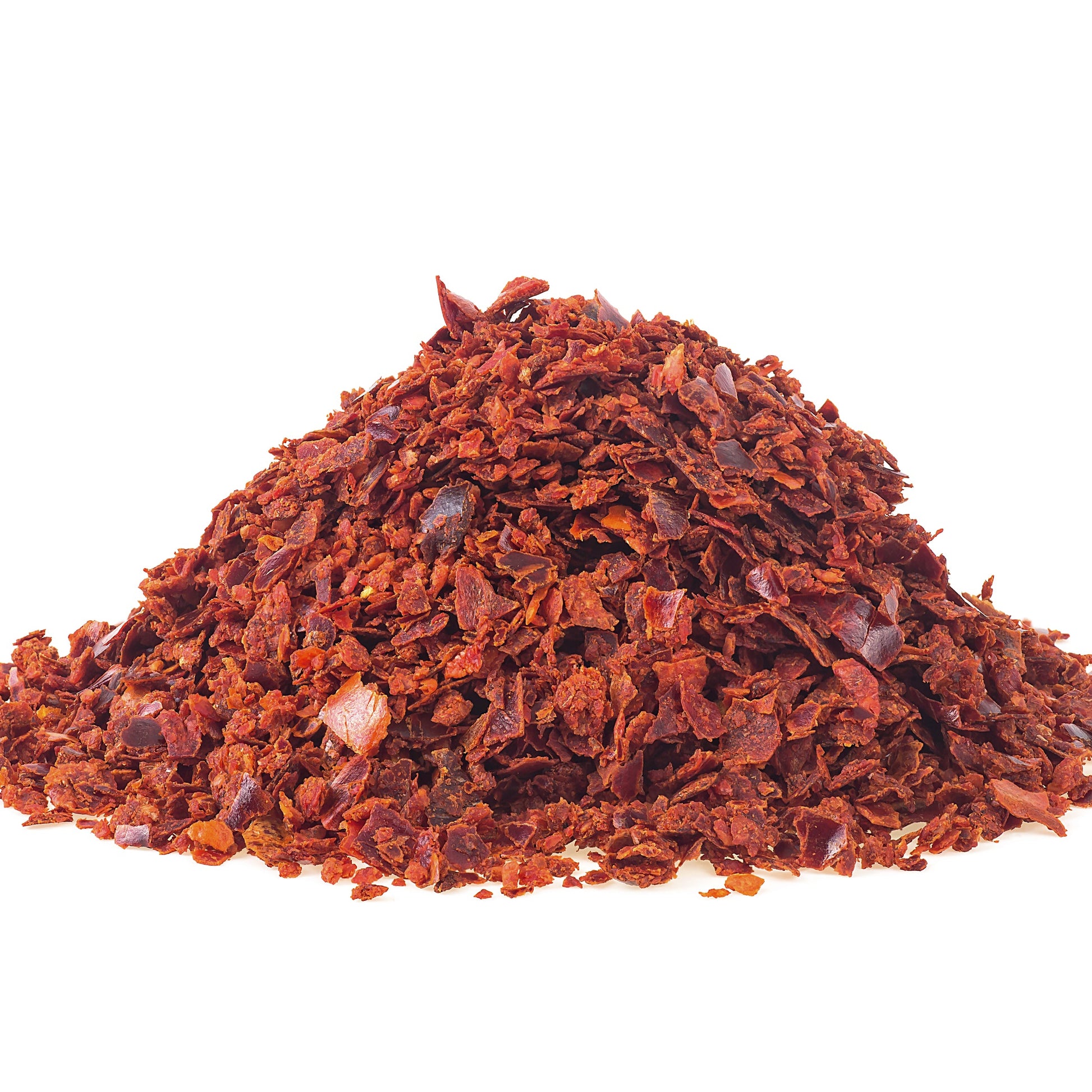 A small mound of ground red chili flakes or chili powder on a plain white background.