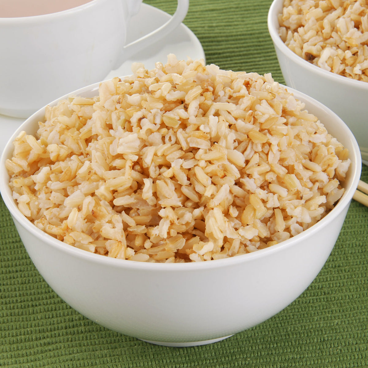 A white ceramic bowl filled with fluffy cooked brown rice, showing the soft texture and light golden-brown colour of the grains, from The Herb Shed Wollongong Australia.