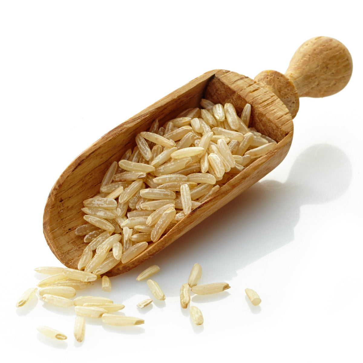 Uncooked Australian Brown Medium Grain Rice displayed in a rustic wooden scoop with loose grains scattered across a white background, from The Herb Shed Wollongong Australia.