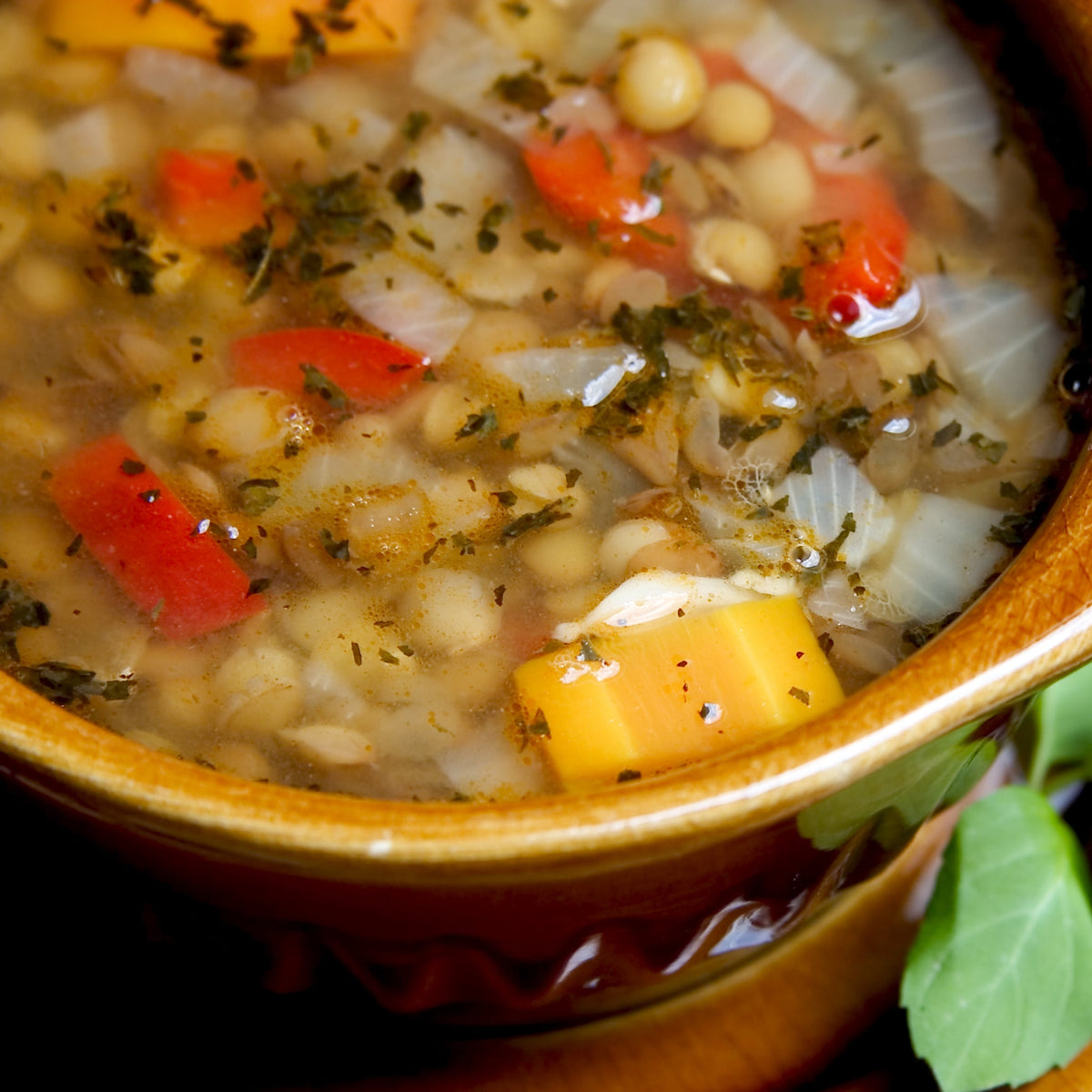 A bowl of hearty vegetable soup with herbs and diced vegetables, showing Australian Cooking Salt Fine used for everyday savoury cooking and seasoning.