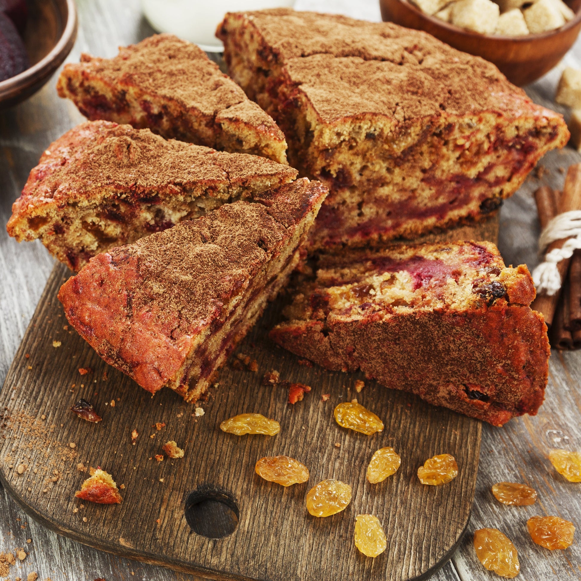 Baked slices made with beetroot powder are stacked on a wooden board, showing their rich reddish-brown colour and dense texture.
