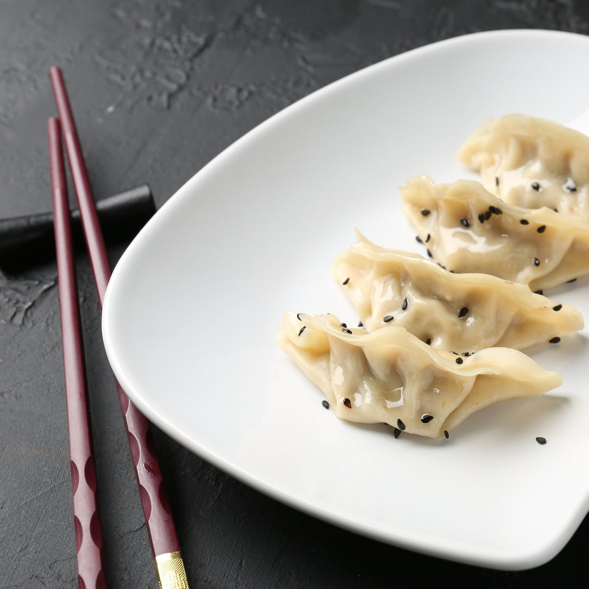 A plate of dumplings sprinkled with Black Sesame Seeds, showing the seeds used as a finishing garnish on a savoury dish.