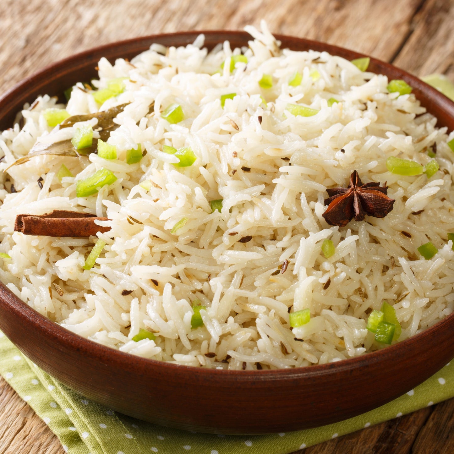 Fluffy white rice seasoned with whole cumin seeds is served in a rustic bowl, showing a savoury cooking use for The Herb Shed Cumin Seeds.