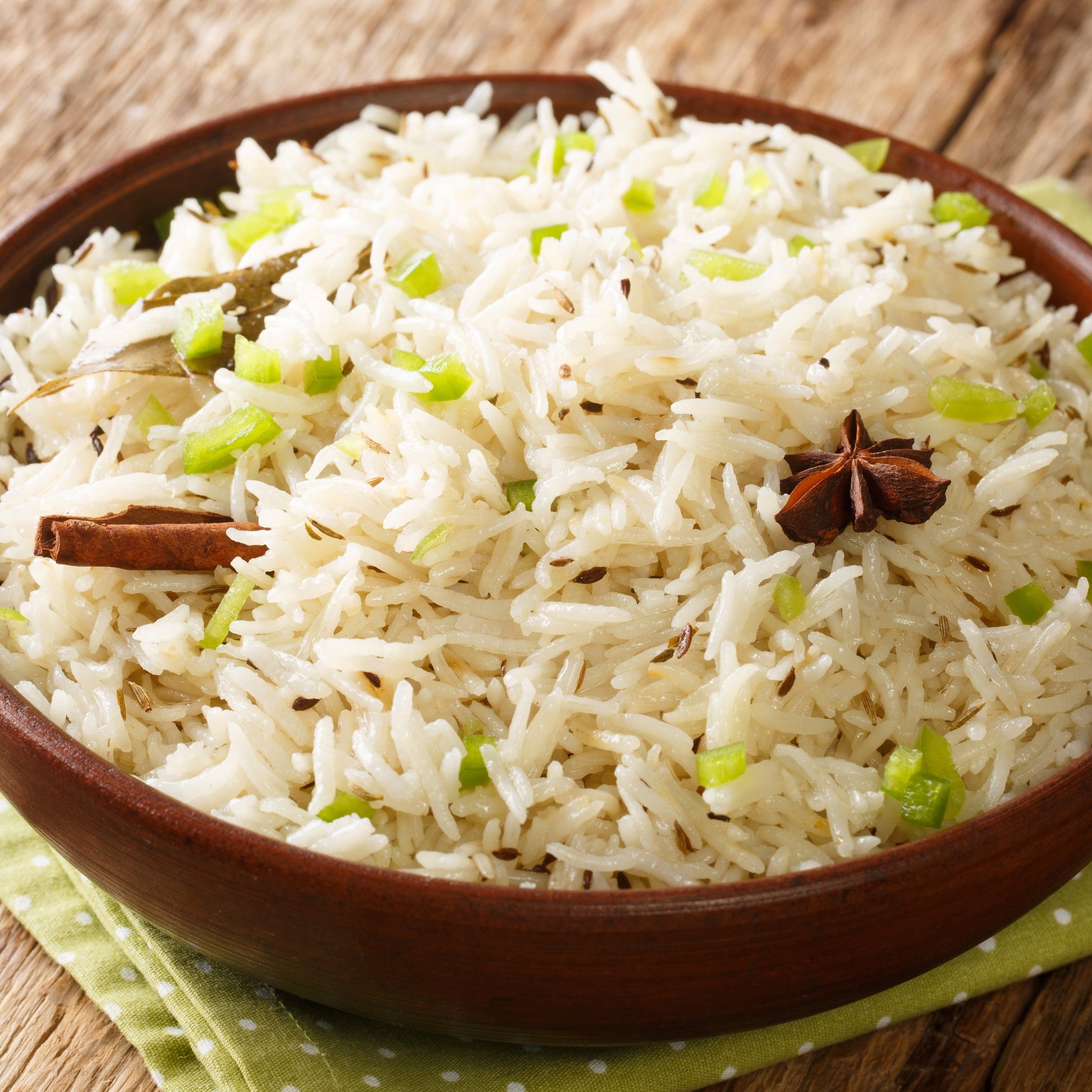 Fluffy white rice seasoned with whole cumin seeds is served in a rustic bowl, showing a savoury cooking use for The Herb Shed Cumin Seeds.