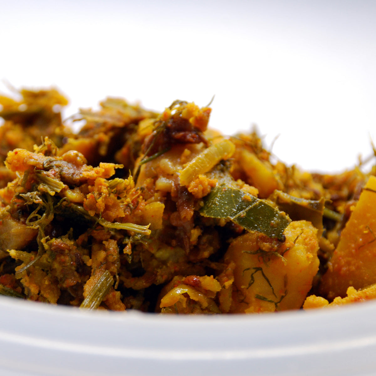 Cooked vegetables seasoned with dried dill tips are served on a white plate, showing a savoury cooking use for dried dill.