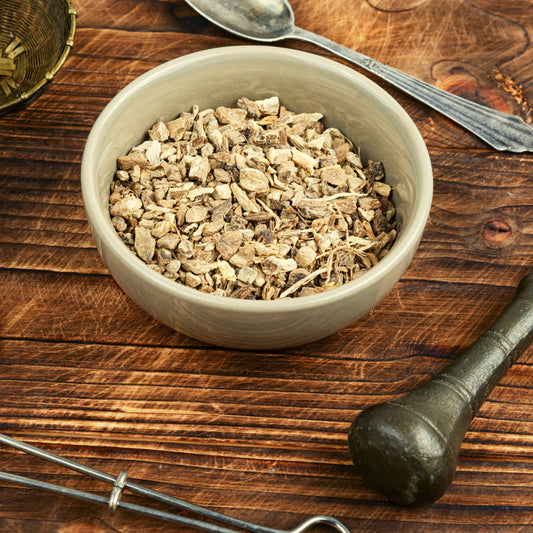 Dried Elecampane from The Herb Shed Wollongong, Australia, shown as chopped root pieces in a bowl on a rustic wooden surface.