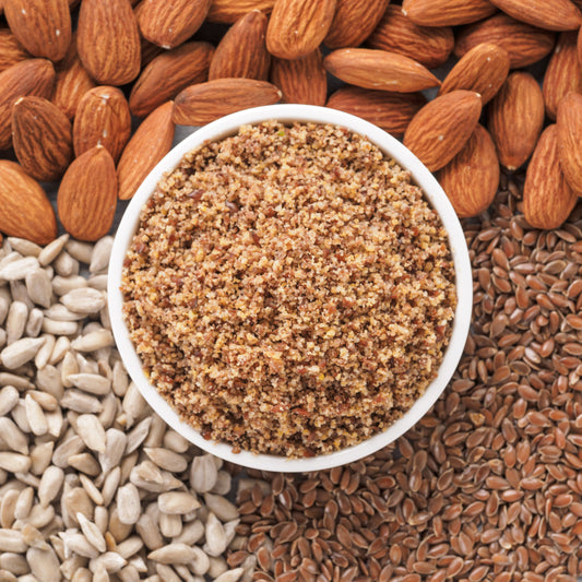 LSA from The Herb Shed Wollongong, Australia, shown in a bowl surrounded by whole almonds, sunflower seeds and linseeds, the three ingredients used in the blend.