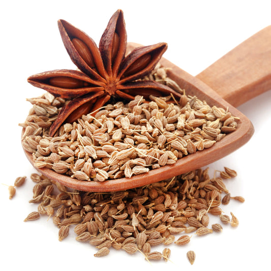 Organic Aniseed fills a small wooden scoop with loose seeds scattered around it and whole star anise displayed alongside.
