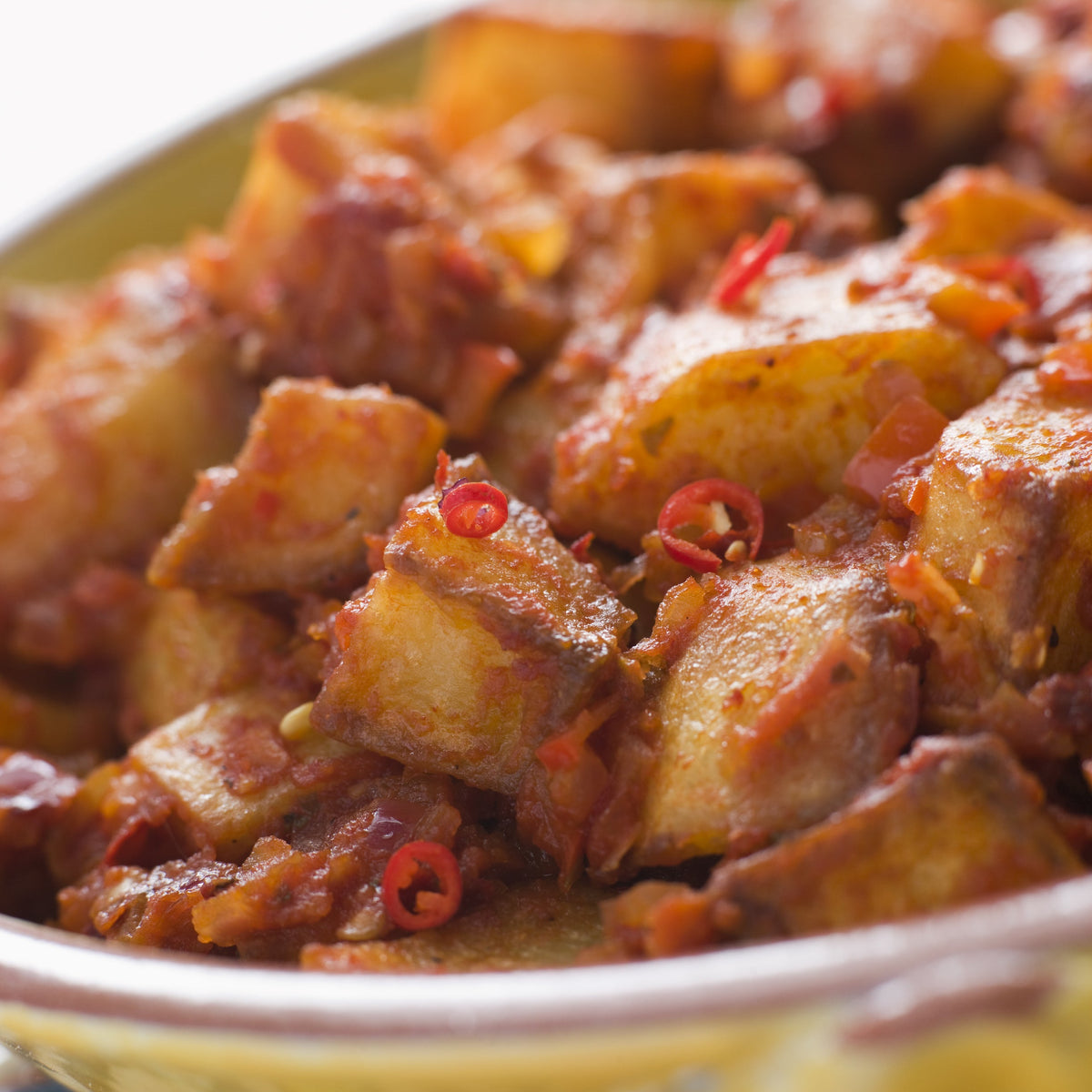 A savoury cooked dish topped with pieces of chilli and seasoning, showing Organic Chilli Mild Rough Cut used to add chilli flavour and texture to cooking.