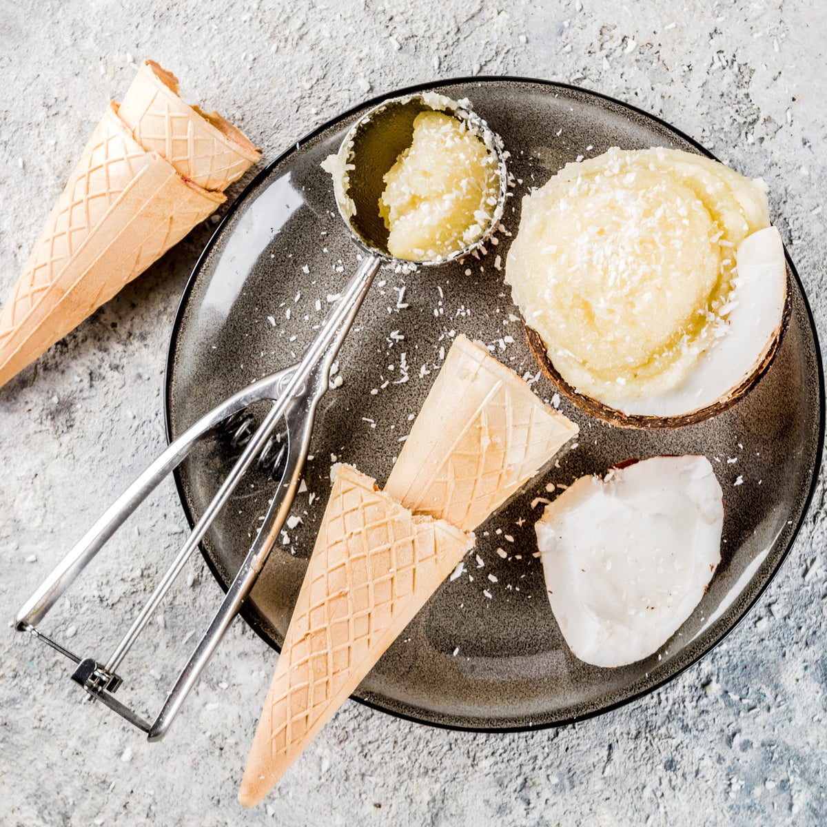 Coconut sugar is arranged with coconut, flour, eggs and baking utensils on a light surface, showing a baking use for The Herb Shed Organic Coconut Sugar.
