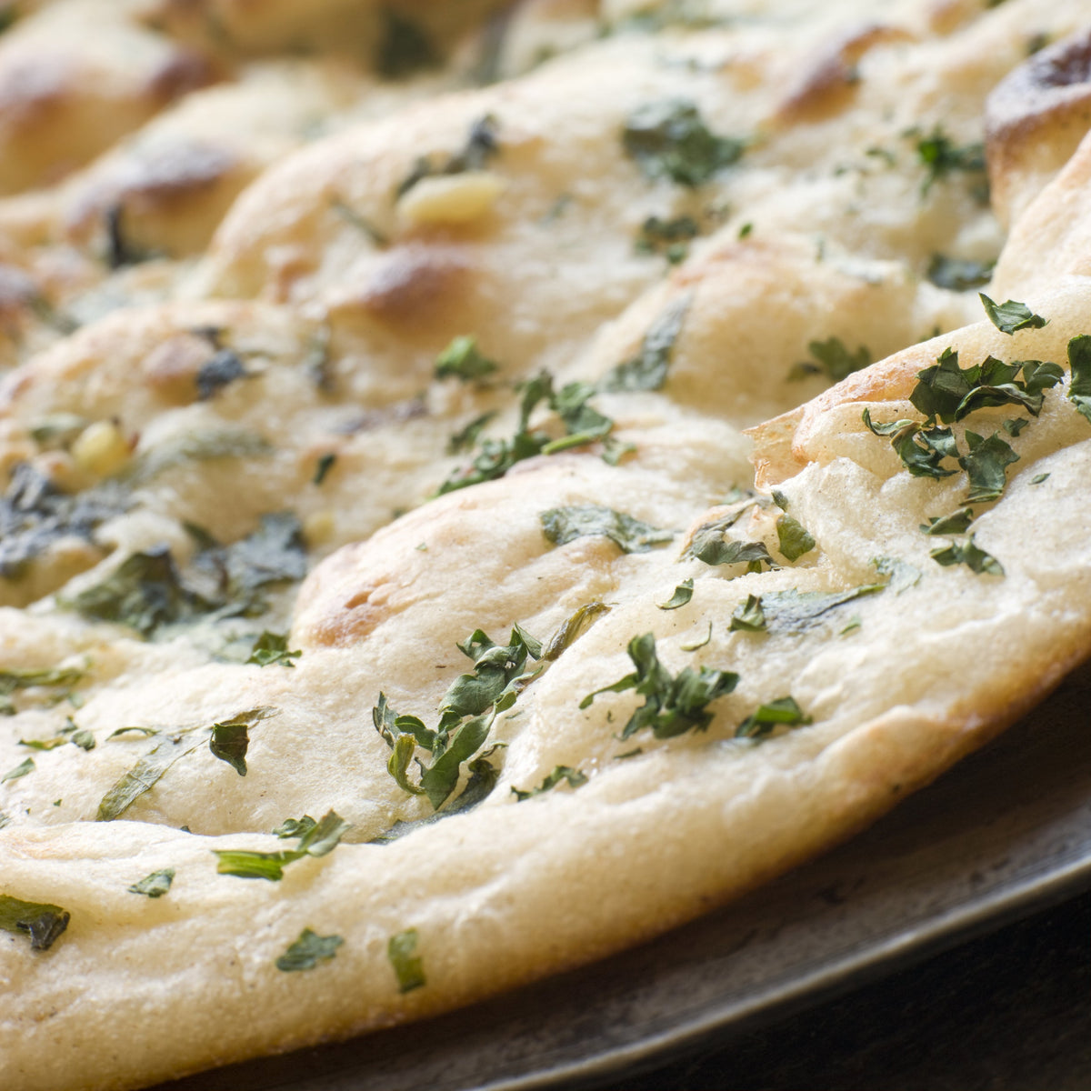 Freshly baked flatbread topped with herbs and coriander seeds, from The Herb Shed Wollongong Australia.