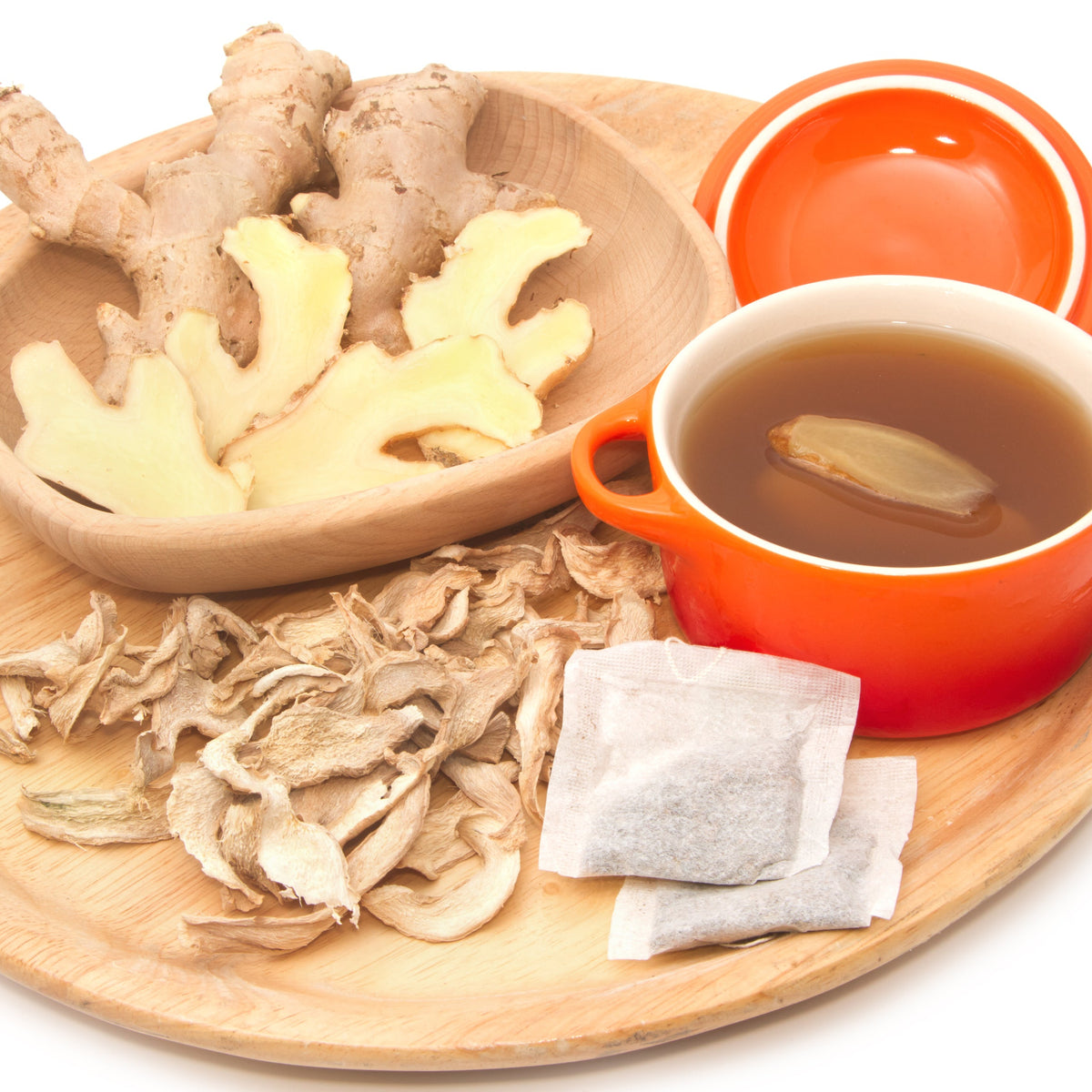 A cup of golden ginger tea beside dried ginger pieces and fresh ginger root, showing Organic Ginger Root Dried from The Herb Shed Wollongong, Australia, prepared as a warming infusion.