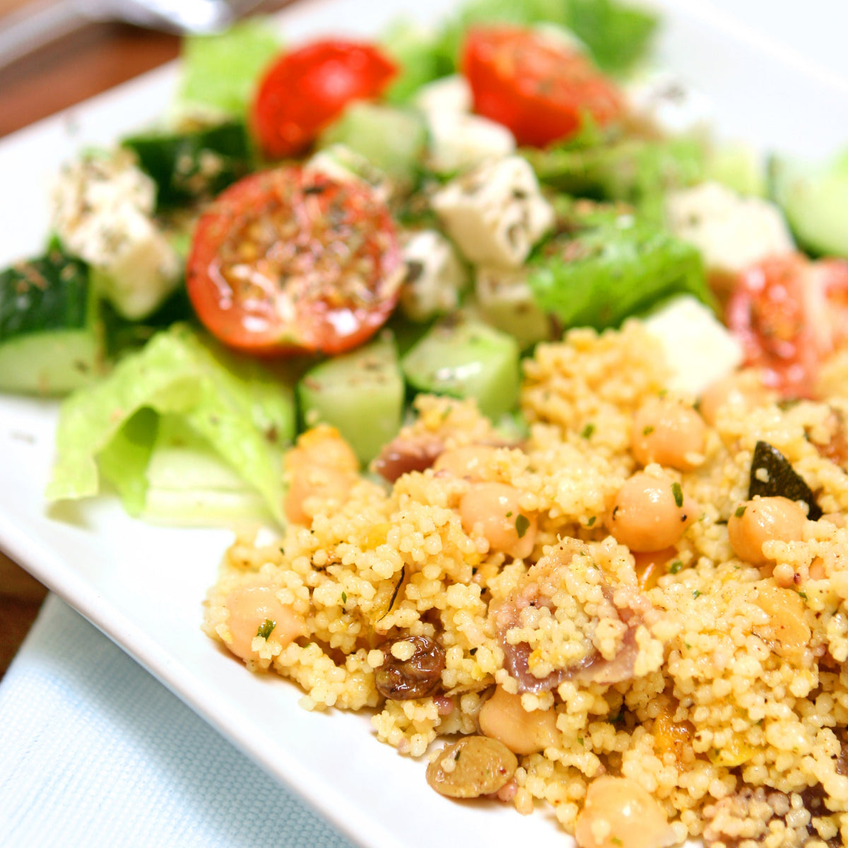 A fresh salad with tomatoes, leafy greens and grains is seasoned with dried oregano, showing a serving idea using The Herb Shed Organic Oregano Dried.
