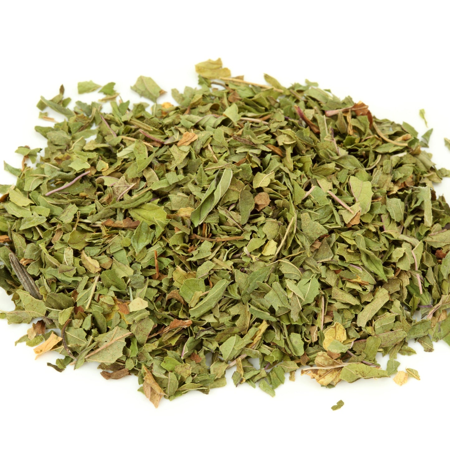 A pile of loose organic peppermint leaf shows the finely cut green and muted brown pieces of the dried herb.