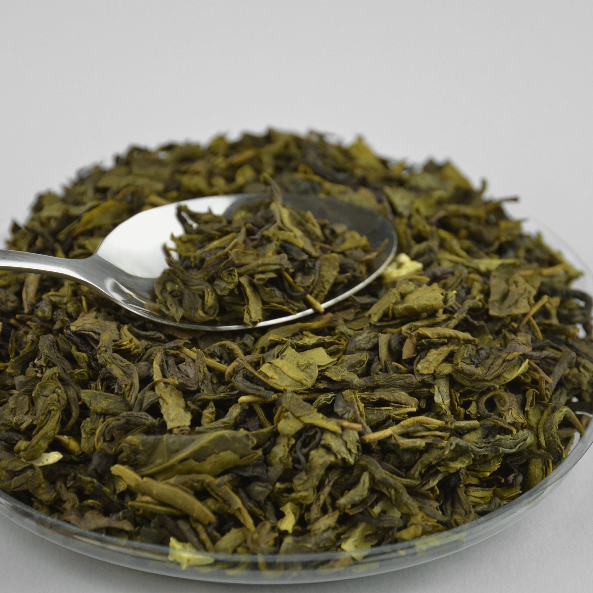 Dried soursop leaf tea in a shallow dish with a metal spoon, loose cut leaves arranged on a light surface from The Herb Shed Wollongong
