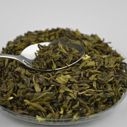 Dried soursop leaf tea in a shallow dish with a metal spoon, loose cut leaves arranged on a light surface from The Herb Shed Wollongong
