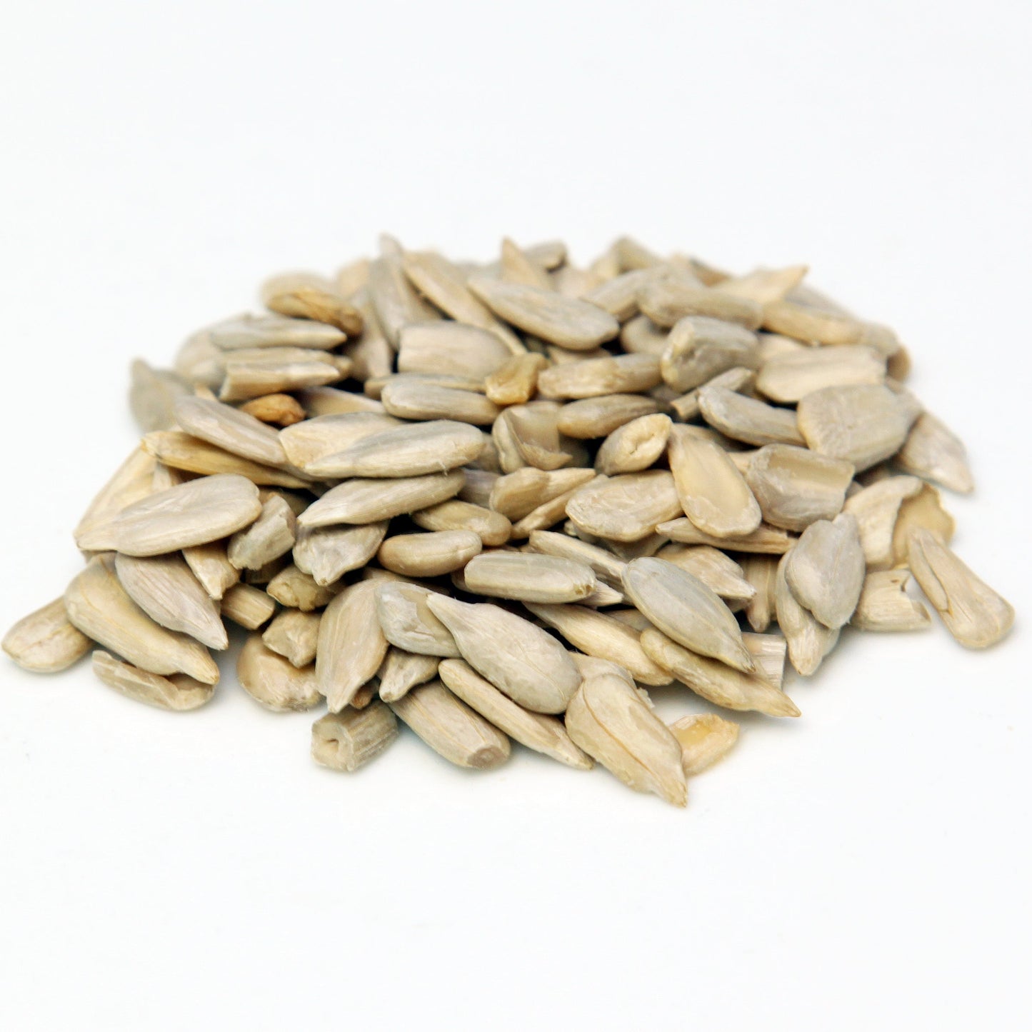 A pile of shelled sunflower seeds sits on a white background, showing the pale cream colour and elongated shape of the kernels.