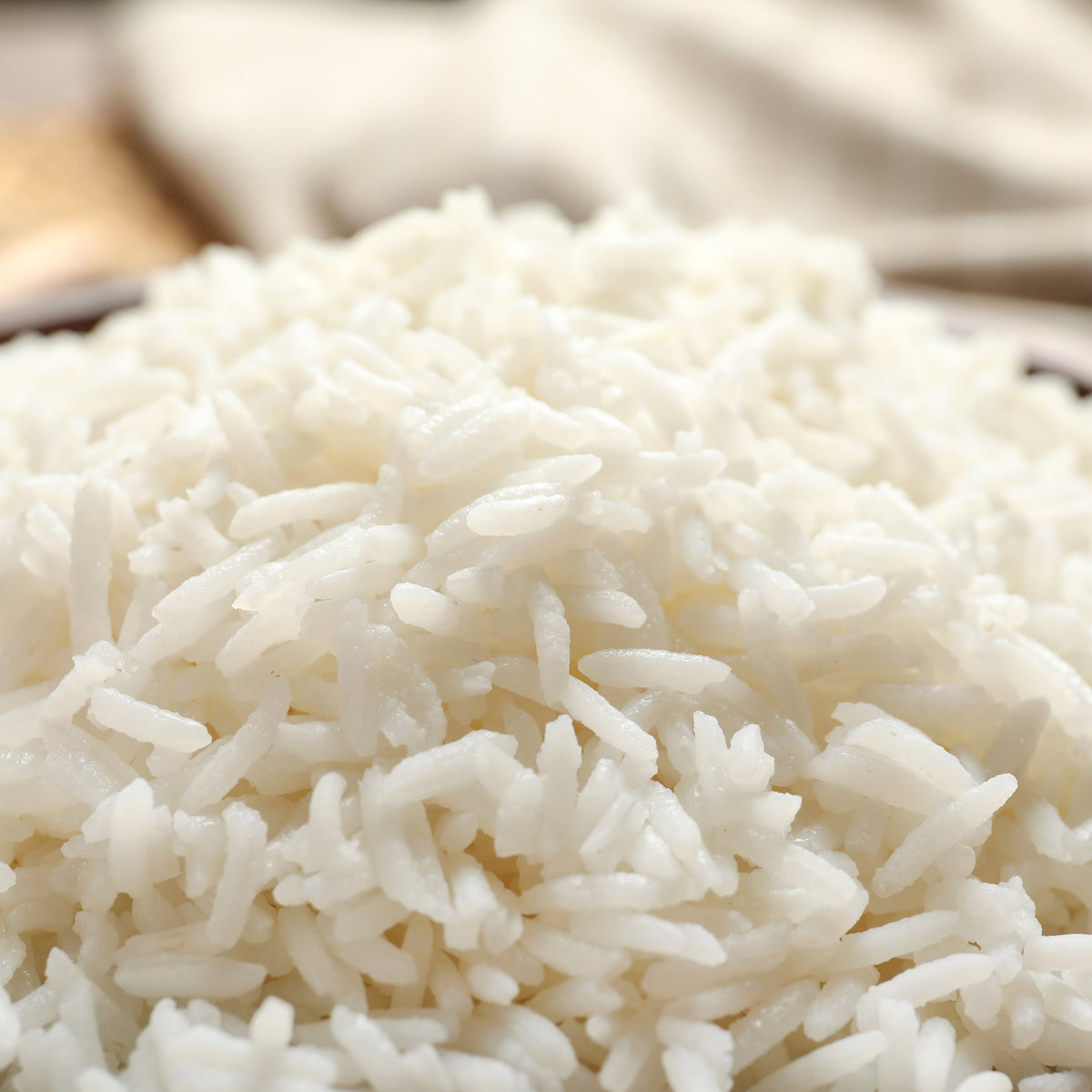 A close-up of fluffy cooked Thai Jasmine Rice showing individual long white grains piled together, with a soft neutral background, from The Herb Shed Wollongong Australia.